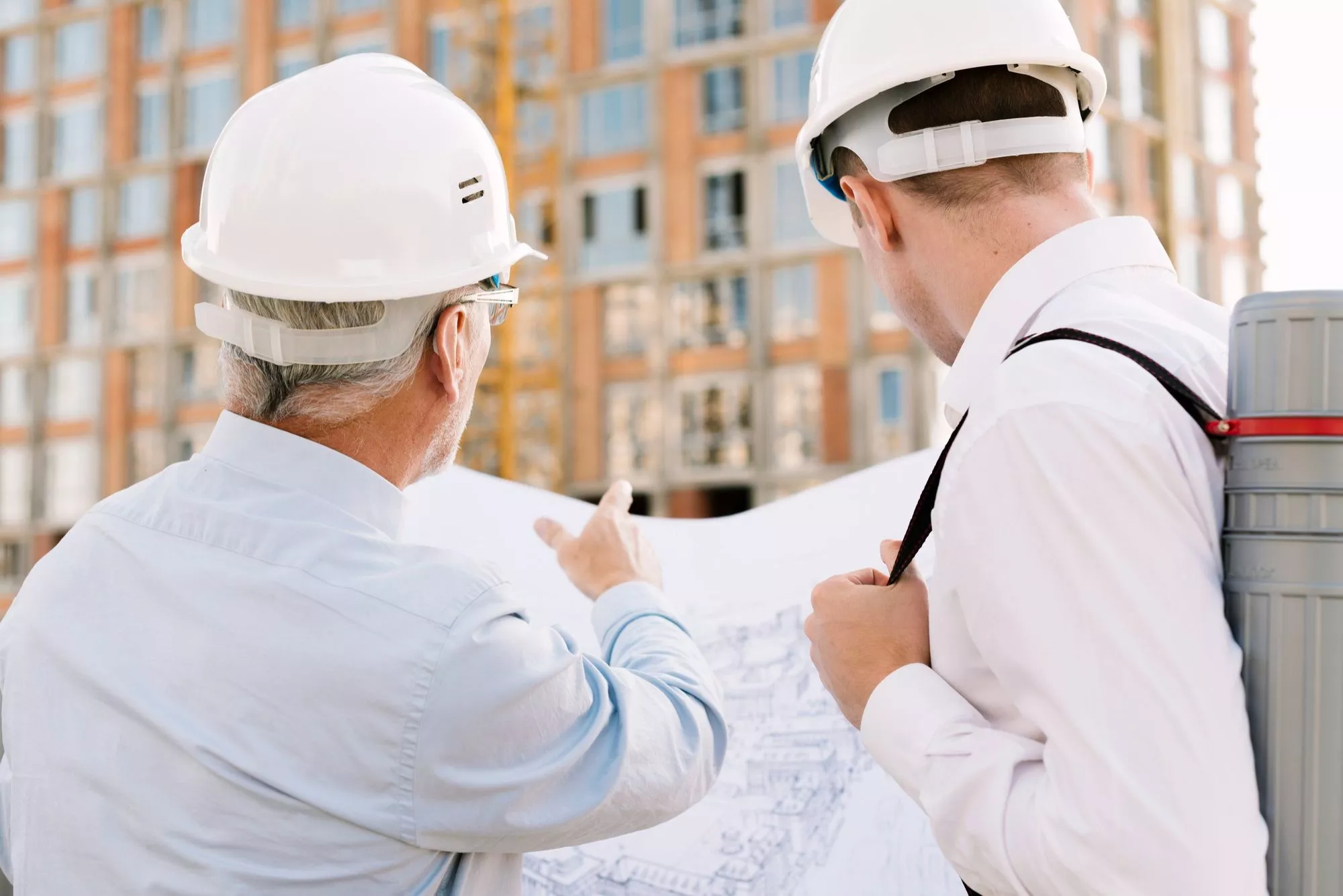 Image Of Two Constructors Looking At A Building Plan | Average Cost of Construction Insurance | HMD Insurance