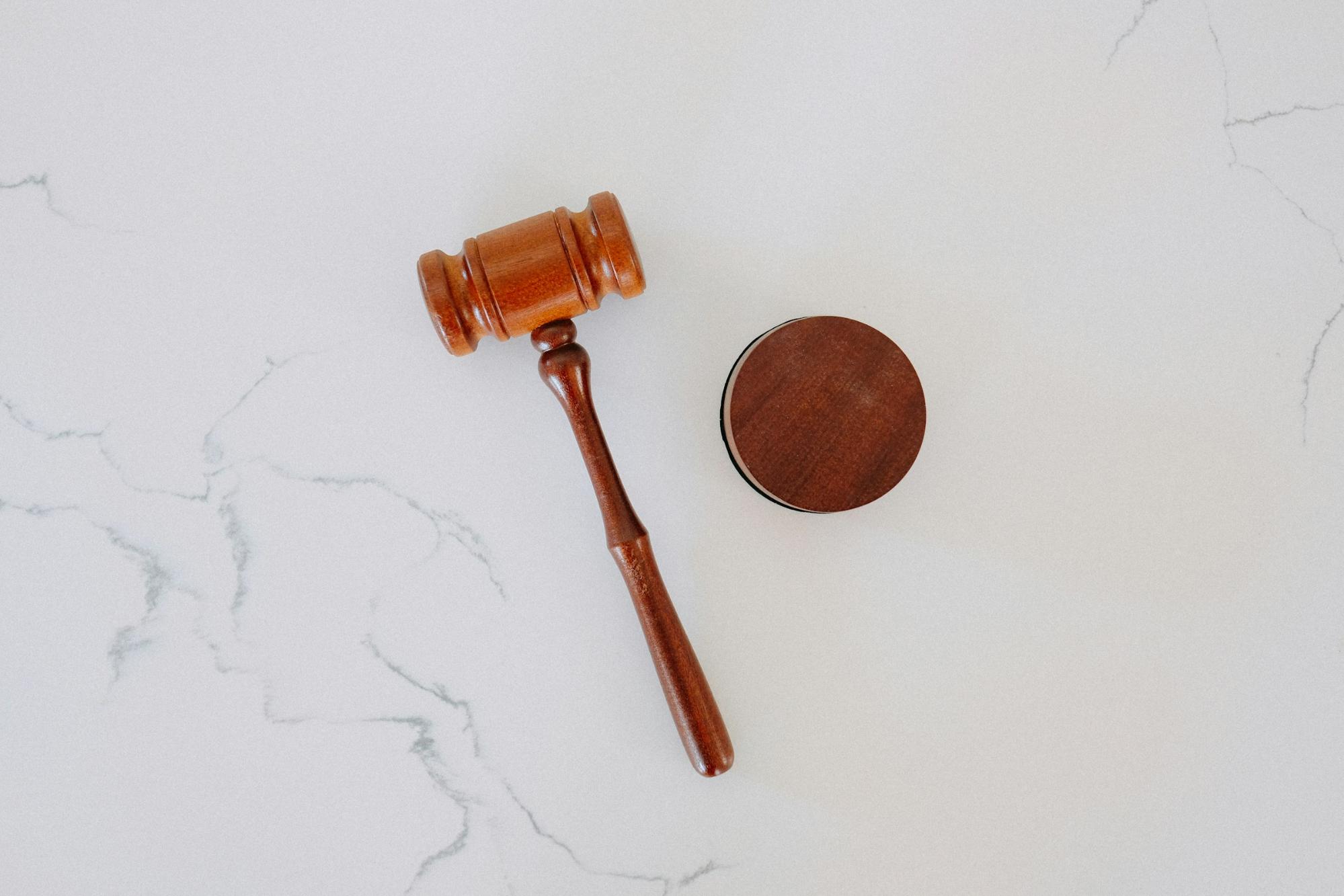 a law court hammer on a white surface